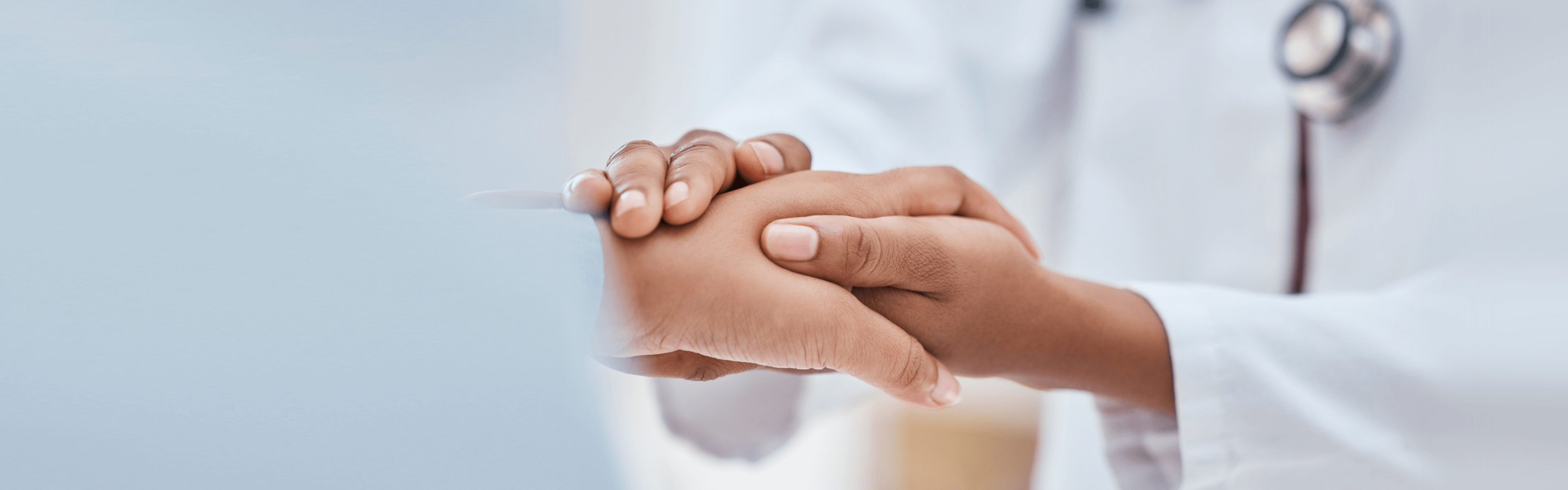 Hände eines Arztes hält unterstützend die Hand des Patienten
