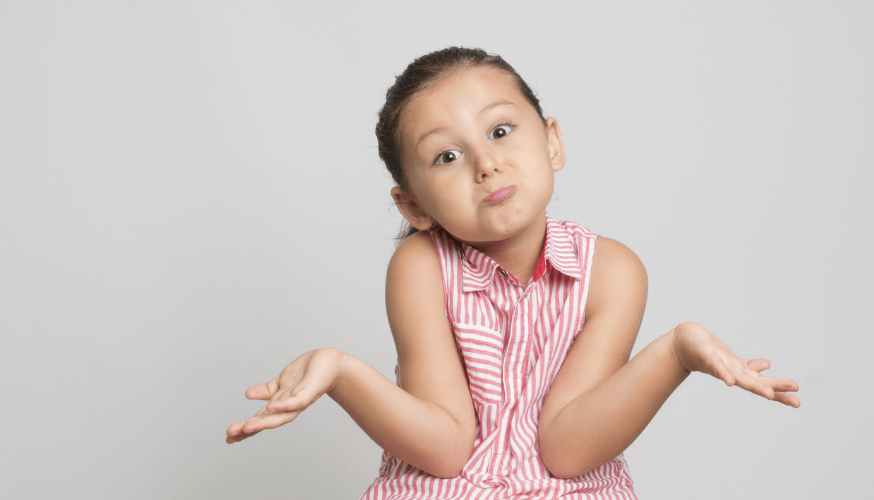 Kleines Mädchen mit fragendem Gesichtsausdruck und ausgebreiteten Händen, trägt gestreifte Bluse, vor einem hellgrauen Hintergrund.